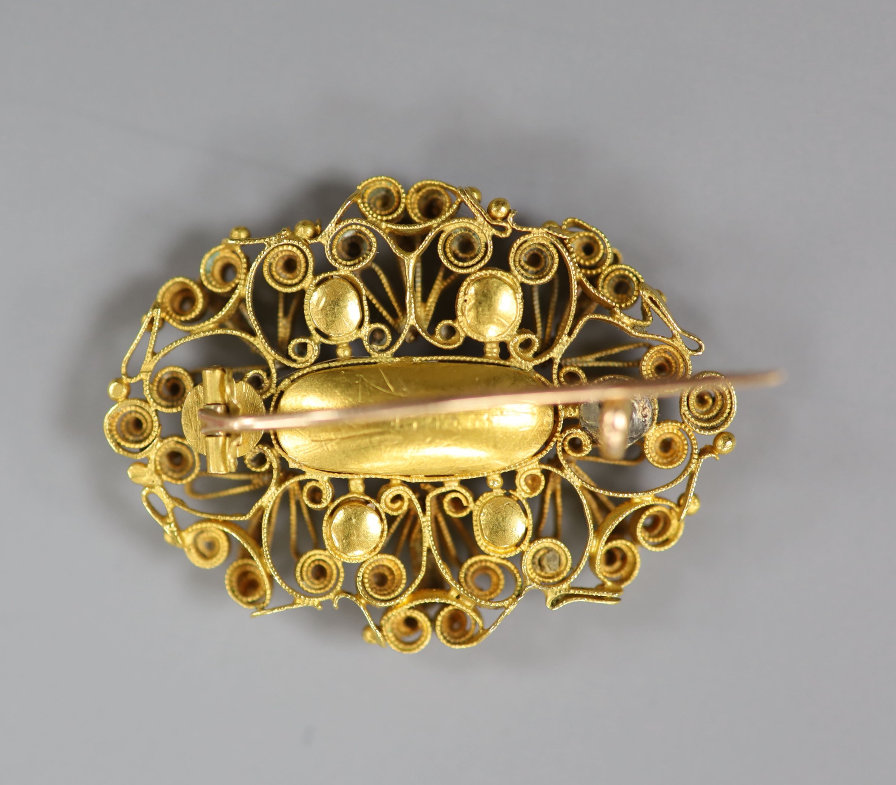 An early 20th century filigree yellow meta, emerald and citrine set oval brooch (emerald missing), 35mm, gross weight 8.4 grams.